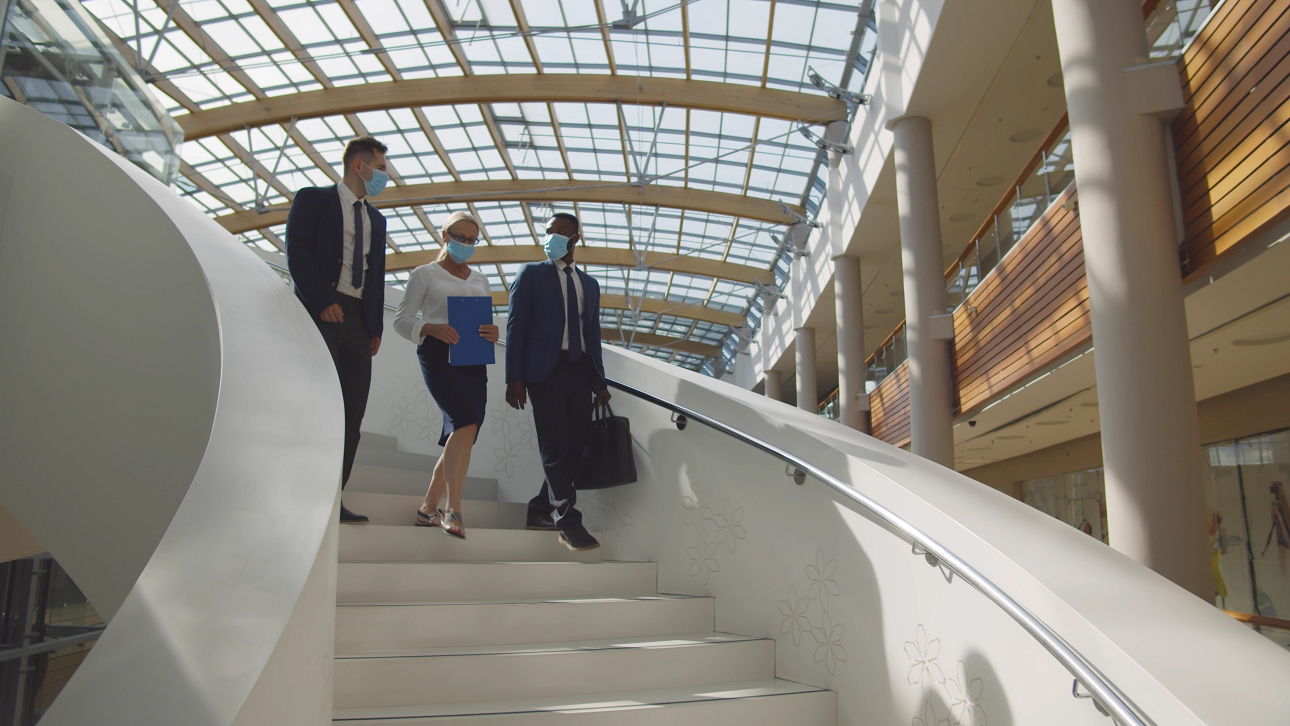 COVID-19マスクをオンにしたビジネスビルの従業員